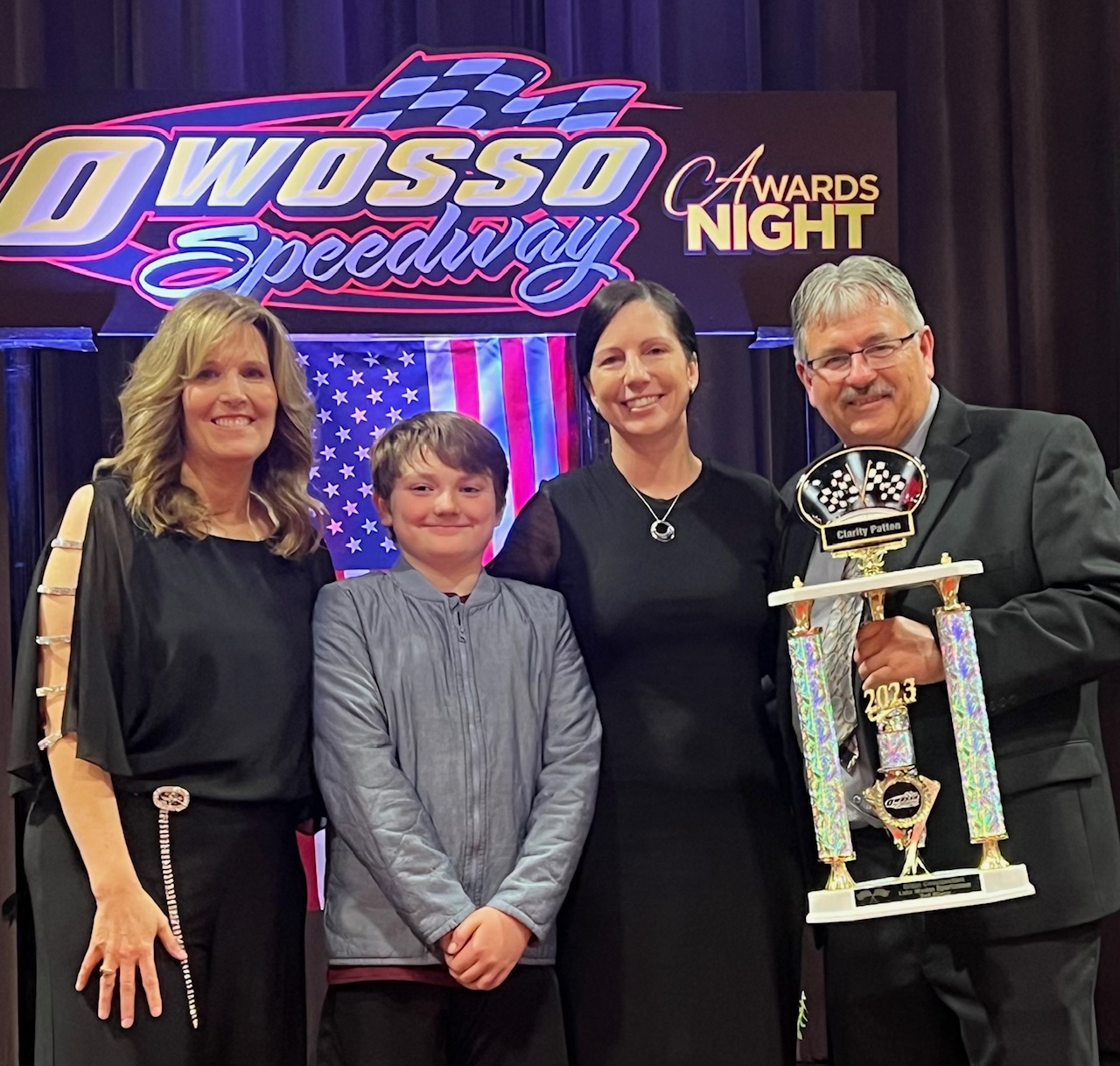 Clarity Patton with family and a trophy at an awards event