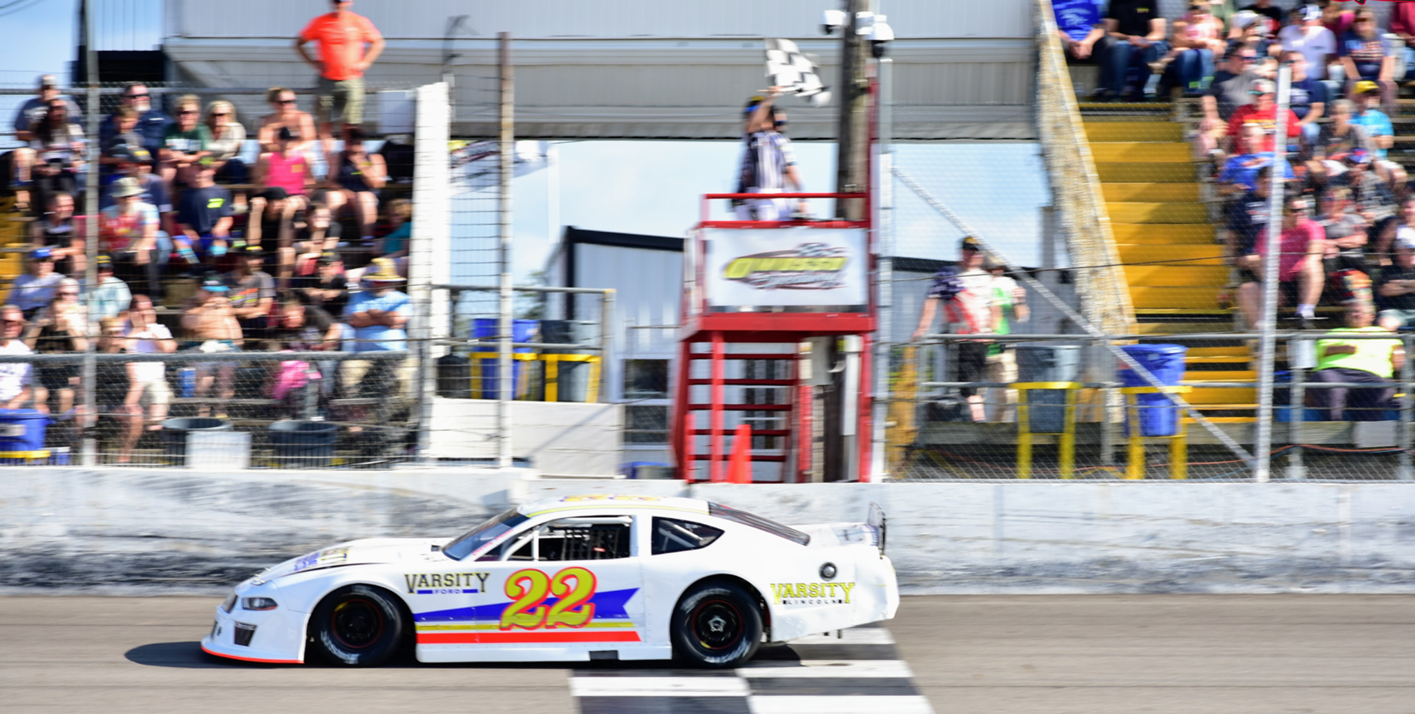 Number 22 race car speeding past the grandstand